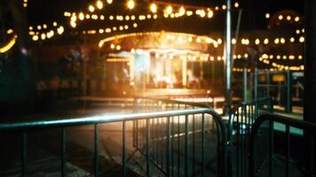Empty amusement park at night with illuminated carousel and barriers video