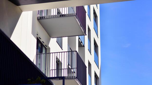 moderno Alto Departamento edificio en blanco, estar alto en contra un azul cielo, ejemplificando innovador urbano arquitectura con pulcro, angular diseños foto