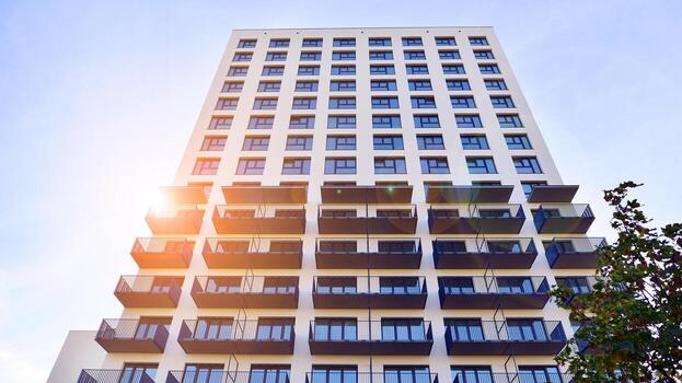 moderno Alto Departamento edificio en blanco, estar alto en contra un azul cielo, ejemplificando innovador urbano arquitectura con pulcro, angular diseños foto