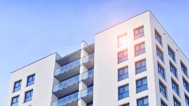 moderno Alto Departamento edificio en blanco, estar alto en contra un azul cielo, ejemplificando innovador urbano arquitectura con pulcro, angular diseños foto