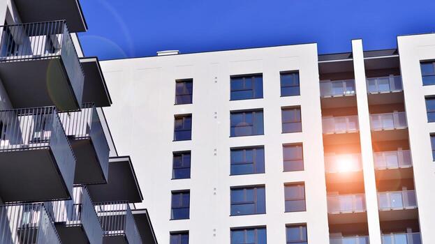 moderno Alto Departamento edificio en blanco, estar alto en contra un azul cielo, ejemplificando innovador urbano arquitectura con pulcro, angular diseños foto