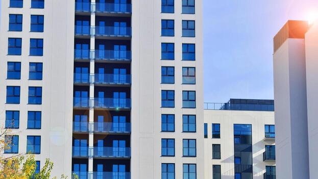 moderno Alto Departamento edificio en blanco, estar alto en contra un azul cielo, ejemplificando innovador urbano arquitectura con pulcro, angular diseños foto