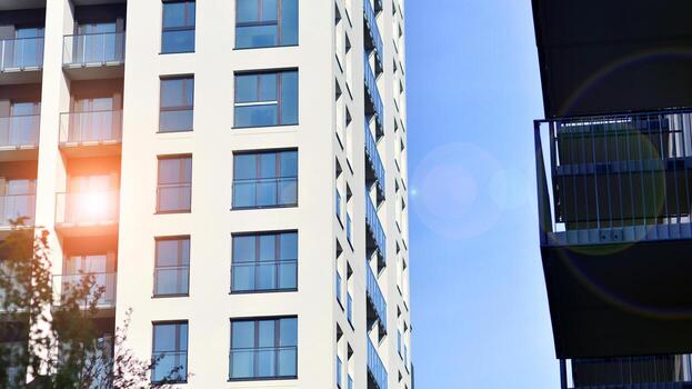 moderno Alto Departamento edificio en blanco, estar alto en contra un azul cielo, ejemplificando innovador urbano arquitectura con pulcro, angular diseños foto