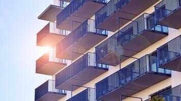 Modern high-rise apartment building in white, stand tall against a blue sky, exemplifying innovative urban architecture with sleek, angular designs. photo