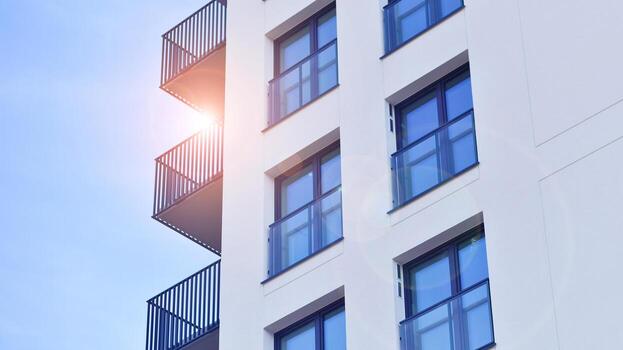 moderno Alto Departamento edificio en blanco, estar alto en contra un azul cielo, ejemplificando innovador urbano arquitectura con pulcro, angular diseños foto