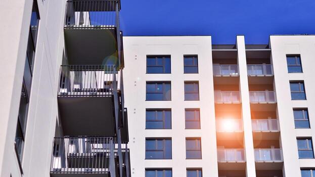 moderno Alto Departamento edificio en blanco, estar alto en contra un azul cielo, ejemplificando innovador urbano arquitectura con pulcro, angular diseños foto