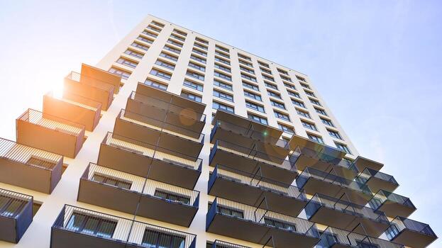 moderno Alto Departamento edificio en blanco, estar alto en contra un azul cielo, ejemplificando innovador urbano arquitectura con pulcro, angular diseños foto