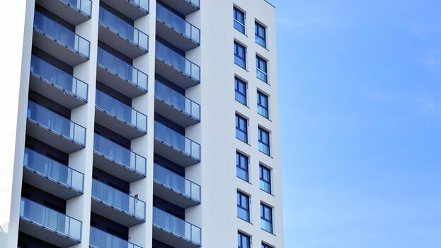 moderno Alto Departamento edificio en blanco, estar alto en contra un azul cielo, ejemplificando innovador urbano arquitectura con pulcro, angular diseños foto