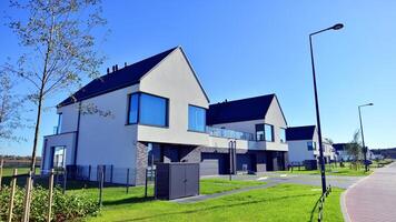 Cityscape with modern townhouses in a residential area, new apartment buildings with green outdoor facilities. Small town residential area with row eco sustainable life building neighborhood suburb. photo