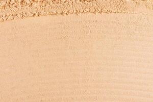 Abstract cosmetic background texture of loose dry powder in natural tone. Soft, parallel texture lines. layout for design. top view. A copy space. photo
