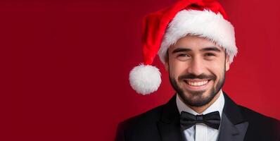 A man wearing black suit and red santa cap on red background representing Christmas photo