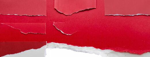 Close-up of a torn red paper edge on a white background, showing a rough texture and contrasting colors. photo