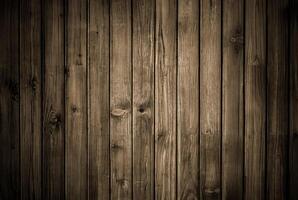 Rustic wooden plank wall with dark tones and visible vertical grain texture, ideal for backgrounds and wood-themed designs. photo