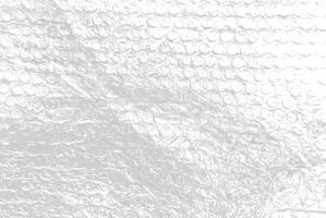High-resolution close-up of bubble wrap texture, showing transparent air-filled pockets on a white background, ideal for packaging, background, or abstract design use. photo