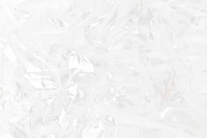 High-resolution close-up of crumpled transparent plastic sheet texture, ideal for use in packaging, backgrounds, or abstract design concepts. photo