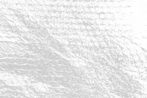 High-resolution close-up of bubble wrap texture, showing transparent air-filled pockets on a white background, ideal for packaging, background, or abstract design use. photo