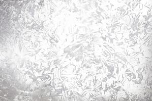 Abstract silver metallic textured background with brushed, irregular patterns, ideal for use in design projects, backgrounds, or as an overlay. photo
