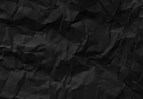 Crumpled black paper texture with wrinkles and folds, ideal for backgrounds and design elements. photo