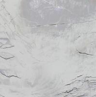 Close-up of a textured stone surface with natural cracks and a soft gradient, ideal for backgrounds and textures. photo