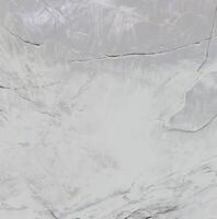 Close-up of a textured stone surface with natural cracks and a soft gradient, ideal for backgrounds and textures. photo