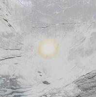 Close-up of a textured stone surface with natural cracks and a soft gradient, ideal for backgrounds and textures. photo