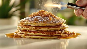 A stack of fluffy pancakes glistens with caramelized sugar as it's enhanced with a flame photo