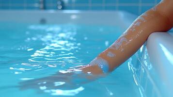 An arm gently rests in the tranquil blue water, evoking calmness and relaxation photo