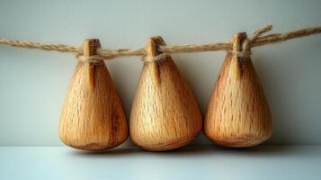 Three beautifully crafted wooden ornaments hanging gracefully on twine indoors photo