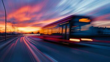 A lively and vibrant scene depicts a speeding bus navigating through an expressway at dusk. The blurred lights create a dynamic movement, while a colorful sunset reflects the essence of urban life photo