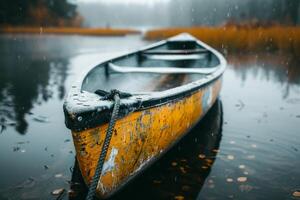 A lone yellow canoe sits in a misty lake surrounded by autumn foliage, capturing the serenity of fall. photo