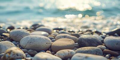 Serene seashore scene with sunlit pebbles and calm waves at sunrise, captured with a focus on texture and tranquility. photo