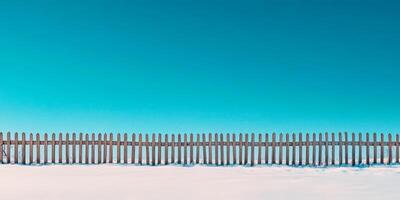 A beautifully serene snowcovered landscape scene features a rustic wooden fence standing against a pristine, expansive white field, which makes it perfect for any kind of text overlay you may desire photo
