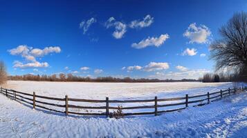 A serene winter scene shows a snowcovered wooden fence leading into a vast snowy field under a bright blue sky, creating an ideal tranquil setting for winterthemed visuals of peace photo