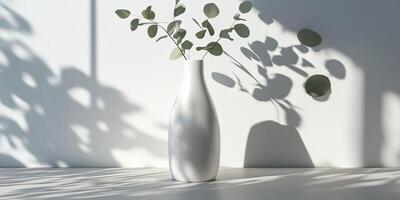 A minimalist white vase filled with vibrant greenery casts soft shadows on a neutral backdrop, showcasing natures simplicity and inherent beauty in an artistic, visually appealing way photo