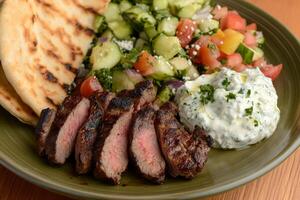 Indulge in a mouthwatering Greek lamb souvlaki plate that comes accompanied by warm pita bread, creamy tzatziki sauce, and a vibrant fresh Greek salad. Its a perfect choice for a flavorful meal photo