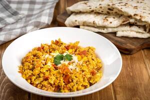 Scrambled Eggs with Pita Bread served in plate isolated on wooden table top view of arabic food photo
