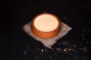 Mishti Doi or Sweet Curd served in clay pot isolated on dark background side view of bangladeshi food photo