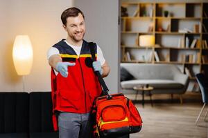 First aid course. A young male paramedic with a bag on his shoulders is standing in a classroom before a lecture photo