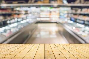 Empty wood table top with supermarket blurred background for product display photo