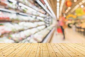 Empty wood table top with supermarket blurred background for product display photo