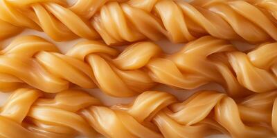 Multiple soft caramel pieces twisted together to form rope-like structures photo