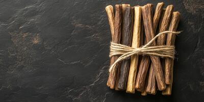 Multiple licorice sticks bundled together with twine in various sizes photo