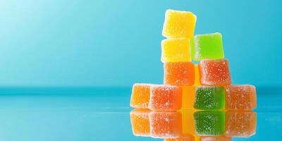 Pyramid stack of cube-shaped gummy candies on a reflective surface photo