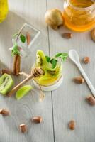 Homemade yogurt in a glass jar with honey, kiwi, nuts. photo