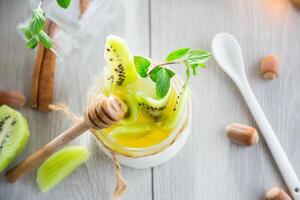 Homemade yogurt in a glass jar with honey, kiwi, nuts. View from above photo