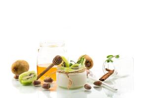 Homemade yogurt in a glass jar with honey, kiwi, nuts. photo
