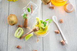 Homemade yogurt in a glass jar with honey, kiwi, nuts. View from above photo