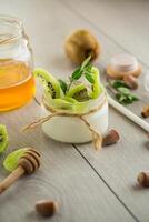 Homemade yogurt in a glass jar with honey, kiwi, nuts. photo