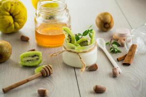 yogurt in a glass jar with honey, kiwi, nuts. photo