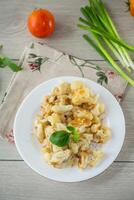 fried diet cauliflower cooked in a plate on a wooden table photo
